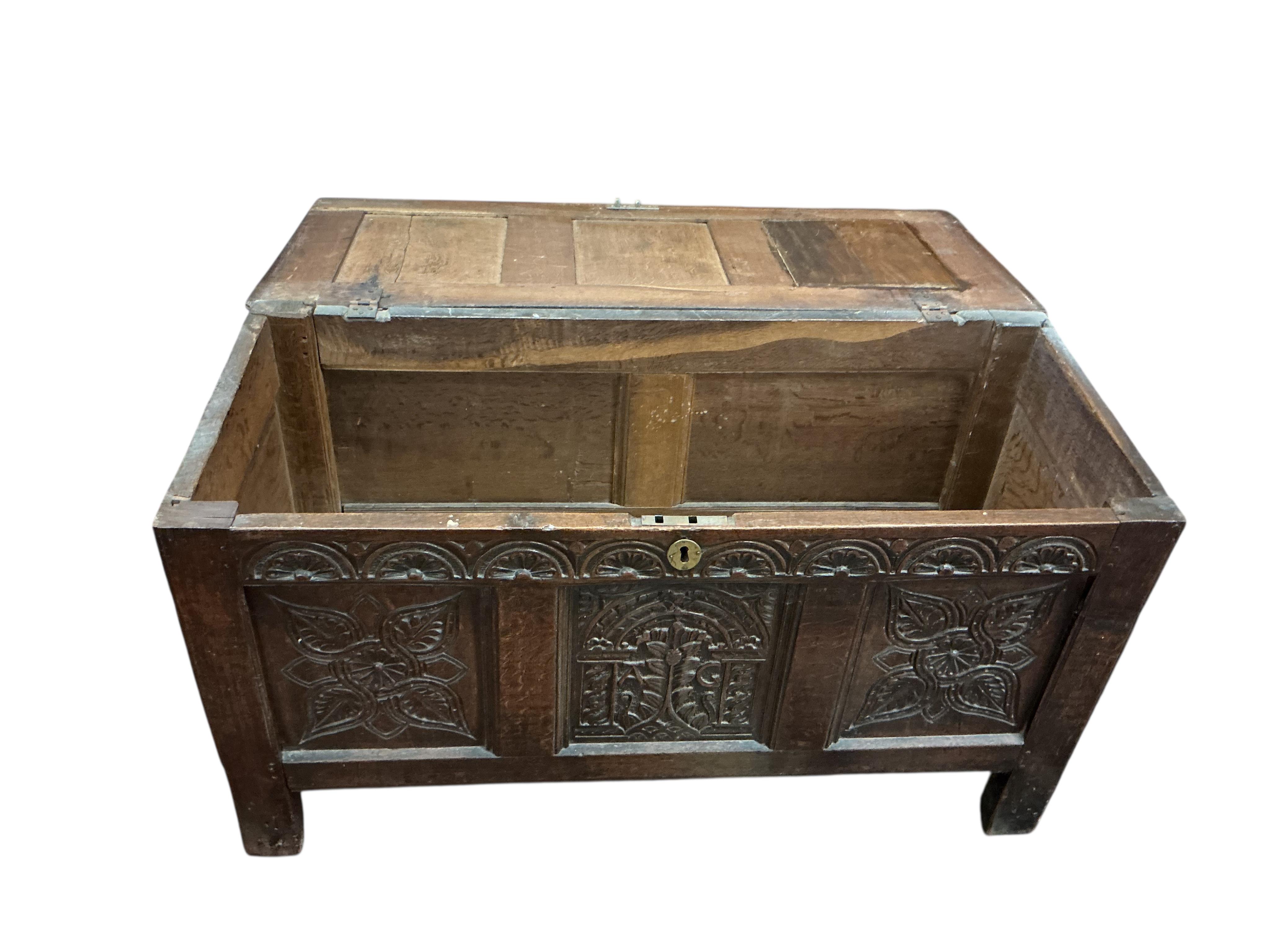 An 18th century carved oak coffer, width 124cm, depth 54cm, height 67cm